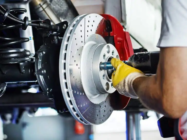 Car mechanic in a garage repairs a bracke